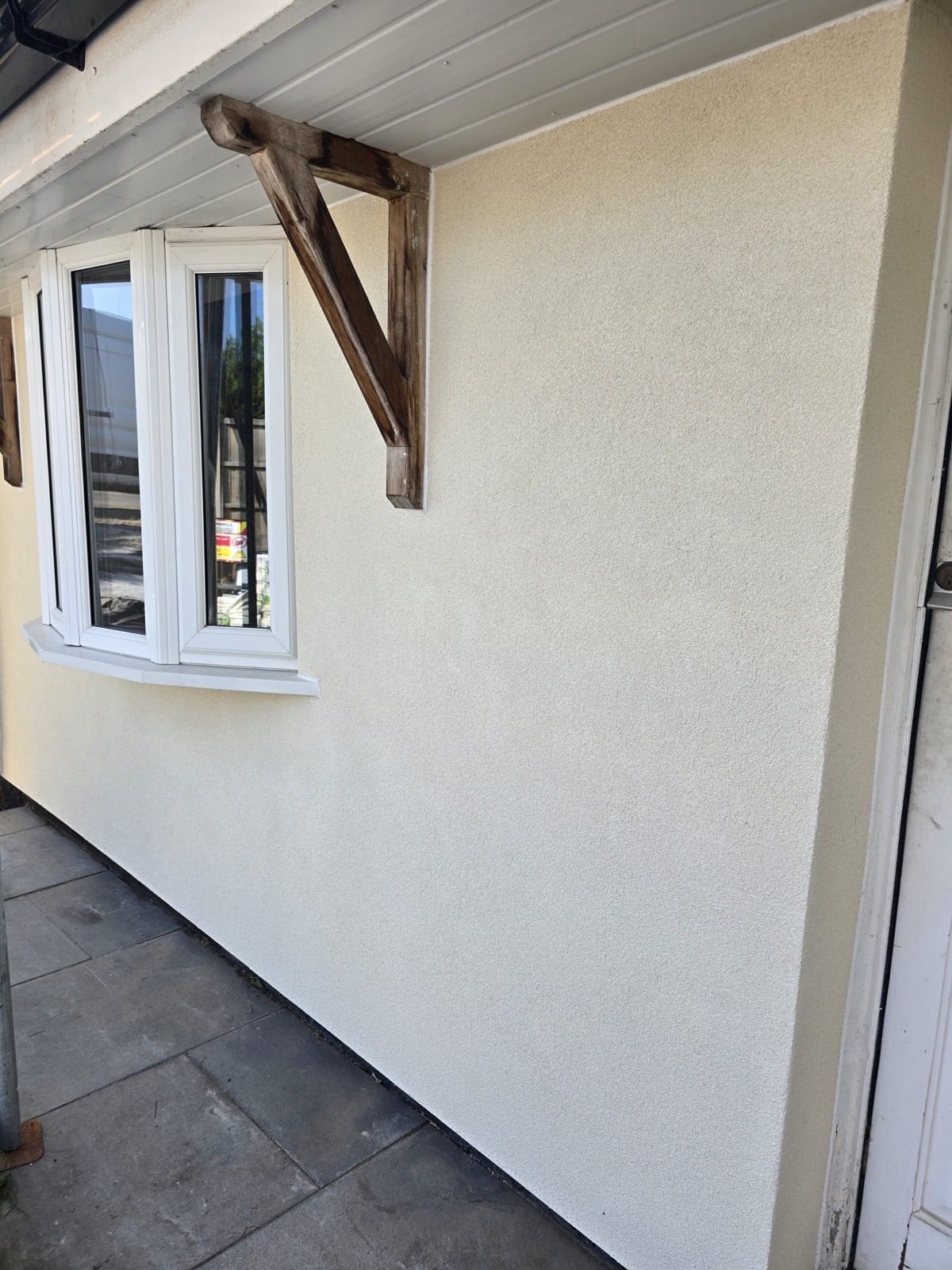 Smooth cream render with oak porch bracket and bay window