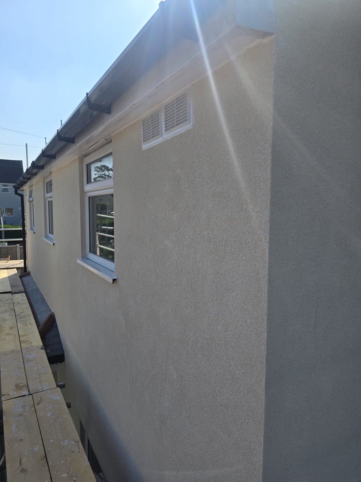 Long finished render elevation with fresh guttering by Leo Rendering, Merseyside
